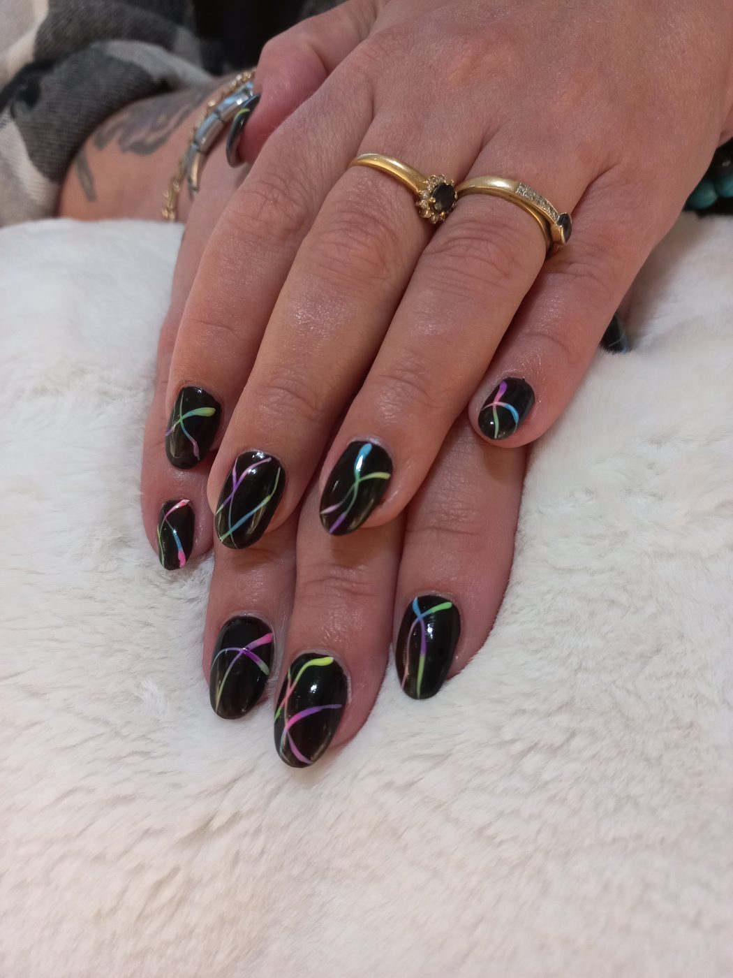 Zwarte nagels met dunne neonlijnen in groen, roze en geel