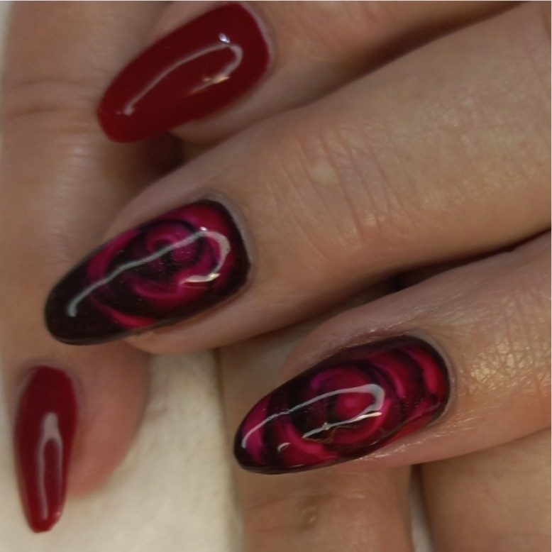 Close-up van donkere nagels met roze rozen